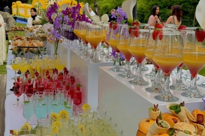 Salle de réception élégante avec tables dressées, chaises transparentes et décoration florale raffinée.