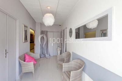 Roc couvert de mousse orné de fleurs colorées, situé dans un parc verdoyant sous des arbres.