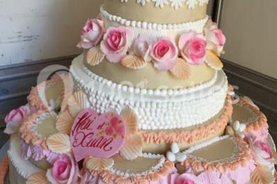 Chambre avec lit rond, couverture rouge, pétales de rose, lampe de chevet et plafond en bois avec suspension plumeuse.