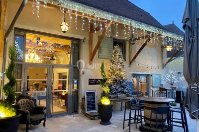 Chambre avec lit rond, couverture rouge, pétales de rose, lampe de chevet et plafond en bois avec suspension plumeuse.
