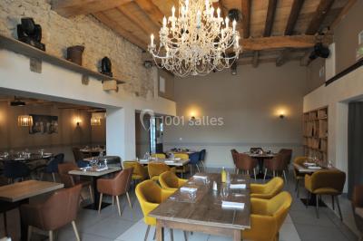 Chambre avec lit rond, couverture rouge, pétales de rose, lampe de chevet et plafond en bois avec suspension plumeuse.