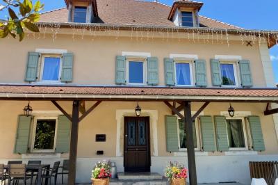 Chambre avec lit rond, couverture rouge, pétales de rose, lampe de chevet et plafond en bois avec suspension plumeuse.