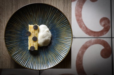 Un couple de dos regarde un feu d'artifice illuminer le ciel nocturne dans un cadre extérieur.