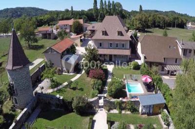 Chambre avec lit rond, couverture rouge, pétales de rose, lampe de chevet et plafond en bois avec suspension plumeuse.