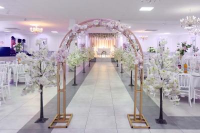 Salle de réception spacieuse avec piste de danse, éclairages colorés et équipement audio sur une estrade.