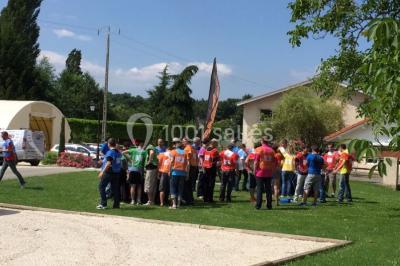 Vue aérienne d'une réception en plein air autour d'une piscine, avec des invités, des tables et des espaces verts…
