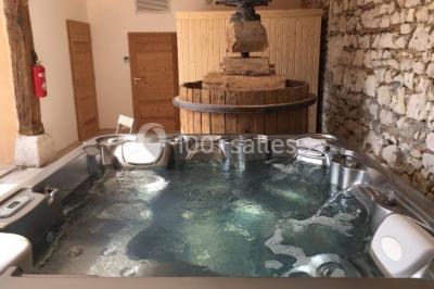 Vue aérienne d'une réception en plein air autour d'une piscine, avec des invités, des tables et des espaces verts…