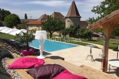 Vue aérienne d'une réception en plein air autour d'une piscine, avec des invités, des tables et des espaces verts…