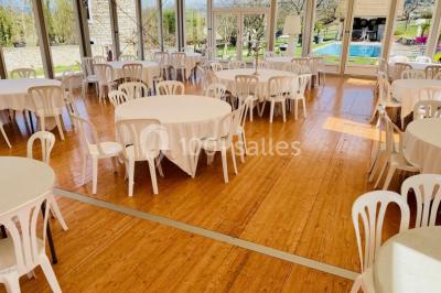 Vue aérienne d'une réception en plein air autour d'une piscine, avec des invités, des tables et des espaces verts…