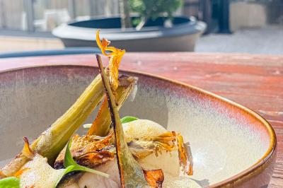 Vue aérienne d'une réception en plein air autour d'une piscine, avec des invités, des tables et des espaces verts…