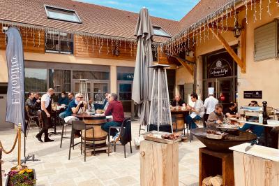 Vue aérienne d'une réception en plein air autour d'une piscine, avec des invités, des tables et des espaces verts…