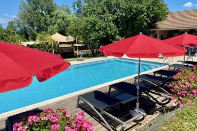 Vue aérienne d'une réception en plein air autour d'une piscine, avec des invités, des tables et des espaces verts…