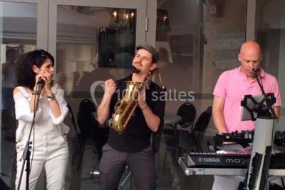 Vue aérienne d'une réception en plein air autour d'une piscine, avec des invités, des tables et des espaces verts…