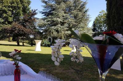 Chambre avec un lit double, draps rayés verts, table de chevet en bois, lampes et sol carrelé beige.