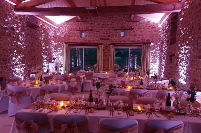 Chambre avec un lit double, draps rayés verts, table de chevet en bois, lampes et sol carrelé beige.