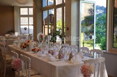 Chambre lumineuse avec lit double, décoration tropicale, plafond avec poutres apparentes et salle de bain attenante.