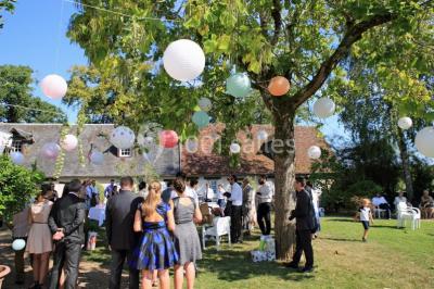 Chambre lumineuse avec lit double, décoration tropicale, plafond avec poutres apparentes et salle de bain attenante.