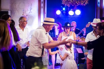 Chambre lumineuse avec lit double, décoration tropicale, plafond avec poutres apparentes et salle de bain attenante.