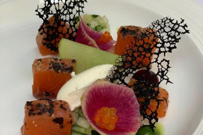 Chambre lumineuse avec lit double, décoration tropicale, plafond avec poutres apparentes et salle de bain attenante.