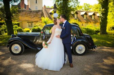 Chambre lumineuse avec lit double, décoration tropicale, plafond avec poutres apparentes et salle de bain attenante.