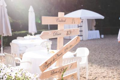 Chambre lumineuse avec lit double, décoration tropicale, plafond avec poutres apparentes et salle de bain attenante.