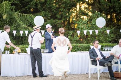 Chambre lumineuse avec lit double, décoration tropicale, plafond avec poutres apparentes et salle de bain attenante.