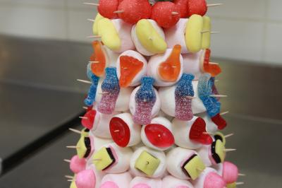 Chambre lumineuse avec lit double, décoration tropicale, plafond avec poutres apparentes et salle de bain attenante.