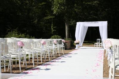 Chambre lumineuse avec lit double, décoration tropicale, plafond avec poutres apparentes et salle de bain attenante.