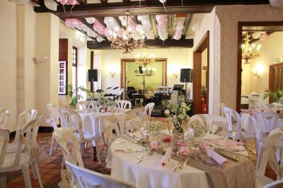 Chambre lumineuse avec lit double, décoration tropicale, plafond avec poutres apparentes et salle de bain attenante.