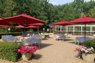 Chambre lumineuse avec lit double, décoration tropicale, plafond avec poutres apparentes et salle de bain attenante.