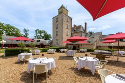 Chambre lumineuse avec lit double, décoration tropicale, plafond avec poutres apparentes et salle de bain attenante.