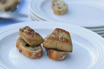 Chambre lumineuse avec lit double, décoration tropicale, plafond avec poutres apparentes et salle de bain attenante.