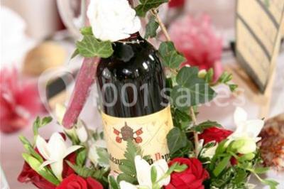 Chambre lumineuse avec lit double, décoration tropicale, plafond avec poutres apparentes et salle de bain attenante.