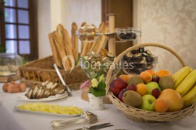 Forêt illuminée par le soleil couchant, avec des arbres espacés et un sentier couvert de feuilles au sol.