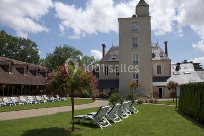 Forêt illuminée par le soleil couchant, avec des arbres espacés et un sentier couvert de feuilles au sol.