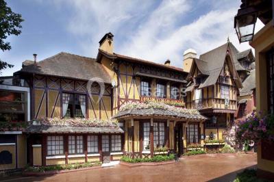 Salle de restaurant élégante avec nappes blanches, grandes fenêtres donnant sur un paysage verdoyant et décoration…