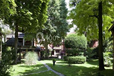 Salle de restaurant élégante avec nappes blanches, grandes fenêtres donnant sur un paysage verdoyant et décoration…