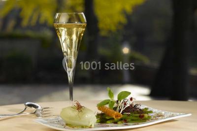 Salle de restaurant élégante avec nappes blanches, grandes fenêtres donnant sur un paysage verdoyant et décoration…