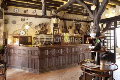 Salle de restaurant élégante avec nappes blanches, grandes fenêtres donnant sur un paysage verdoyant et décoration…