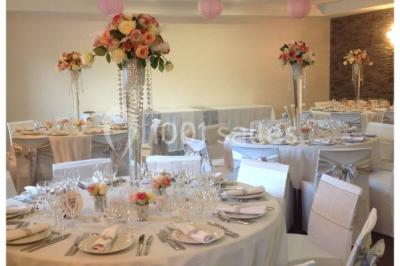 Cuisine professionnelle avec équipements en inox, fours encastrés, étagères murales et hotte d'extraction.