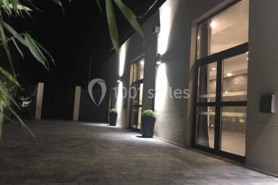 Cuisine professionnelle avec équipements en inox, fours encastrés, étagères murales et hotte d'extraction.