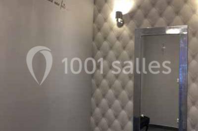 Cuisine professionnelle avec équipements en inox, fours encastrés, étagères murales et hotte d'extraction.