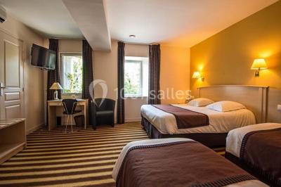 Bâtiment d'hôtel en pierre avec trois étoiles, entouré de végétation et d'une façade partiellement recouverte de lierre.