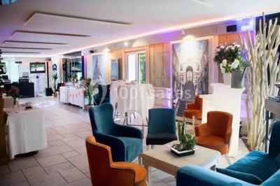 Bâtiment d'hôtel en pierre avec trois étoiles, entouré de végétation et d'une façade partiellement recouverte de lierre.