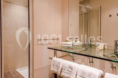 Bâtiment d'hôtel en pierre avec trois étoiles, entouré de végétation et d'une façade partiellement recouverte de lierre.