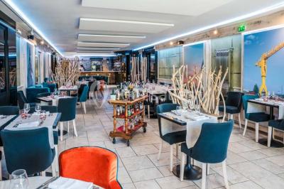 Bâtiment d'hôtel en pierre avec trois étoiles, entouré de végétation et d'une façade partiellement recouverte de lierre.