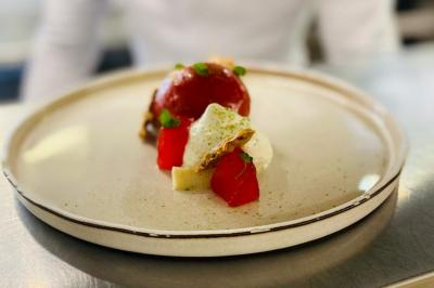 Bâtiment d'hôtel en pierre avec trois étoiles, entouré de végétation et d'une façade partiellement recouverte de lierre.