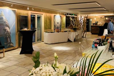 Bâtiment d'hôtel en pierre avec trois étoiles, entouré de végétation et d'une façade partiellement recouverte de lierre.