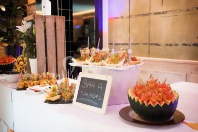 Bâtiment d'hôtel en pierre avec trois étoiles, entouré de végétation et d'une façade partiellement recouverte de lierre.