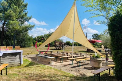 Bâtiment d'hôtel en pierre avec trois étoiles, entouré de végétation et d'une façade partiellement recouverte de lierre.